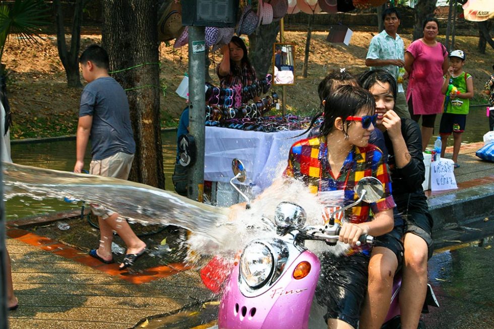 Water splashing while driving a bike during Songkran Festival | Happymind Travels