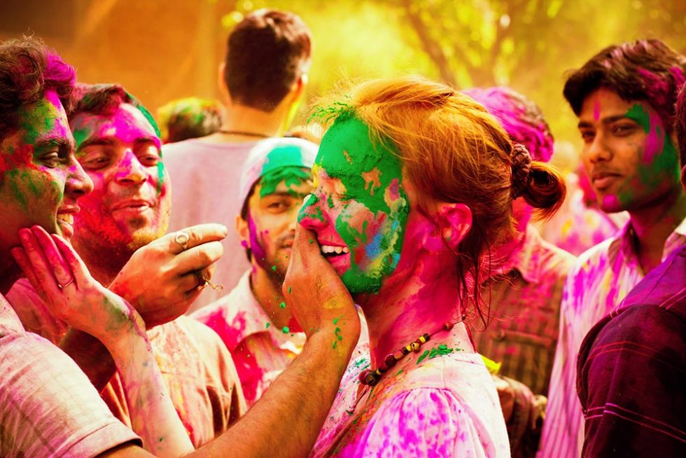 Mulher a ser pintada durante o Festival Holi em Delhi na India | Happymind Travels